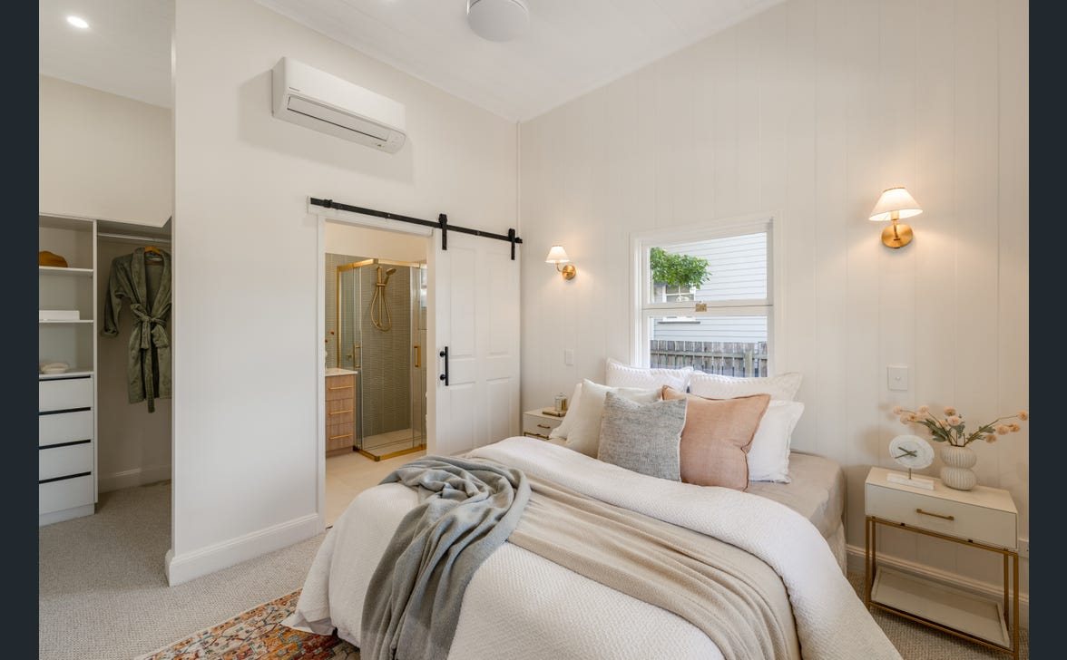 Master bedroom with bedside wall lights and air conditioning
